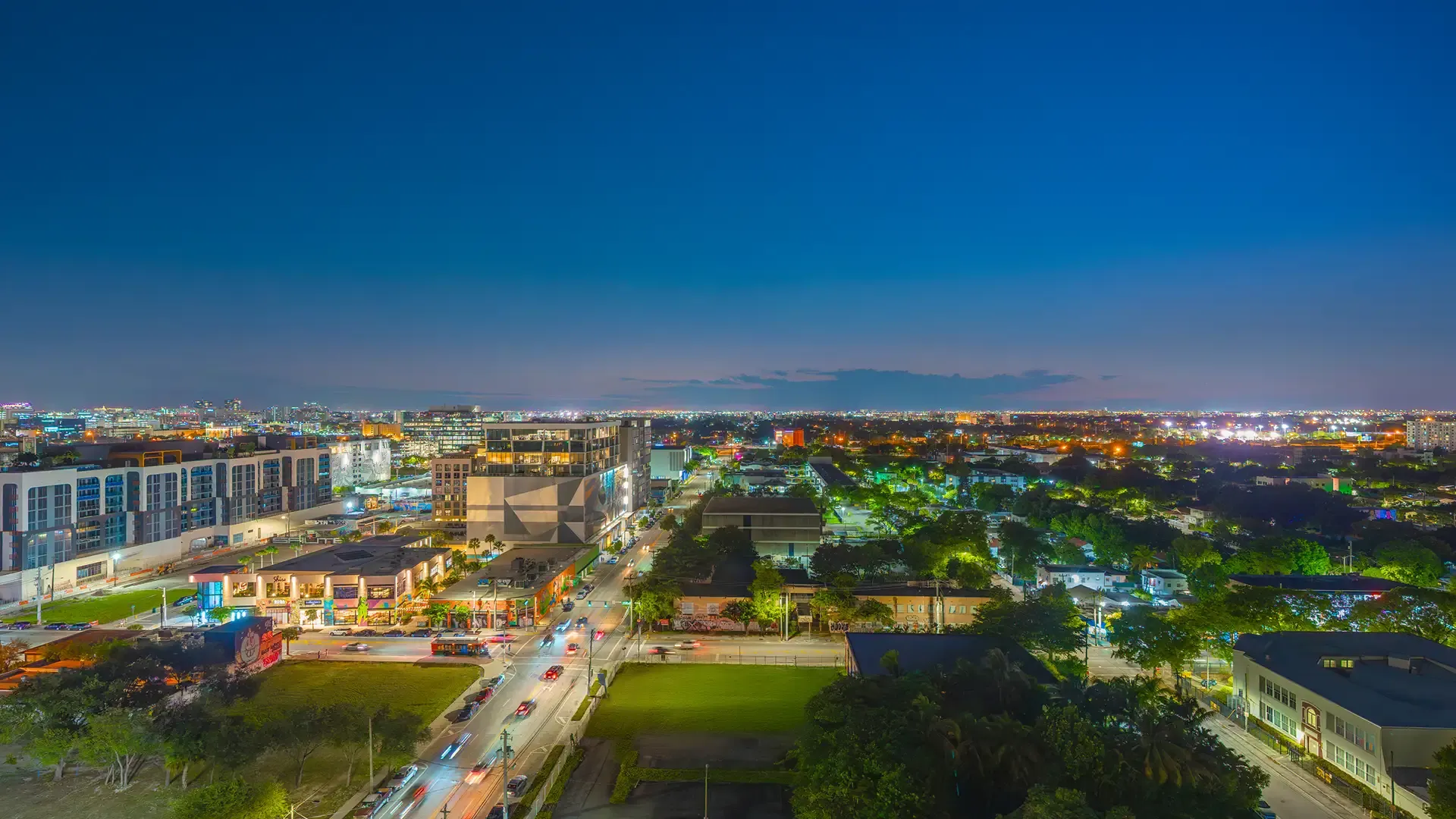 Wynwood ao anoitecer com ruas iluminadas e o horizonte de Miami