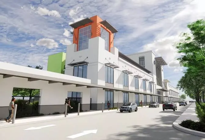 Fachada da escola Mater Academy em SoLé Mia, com torre alaranjada, passarela coberta na entrada e carros na via de circulação